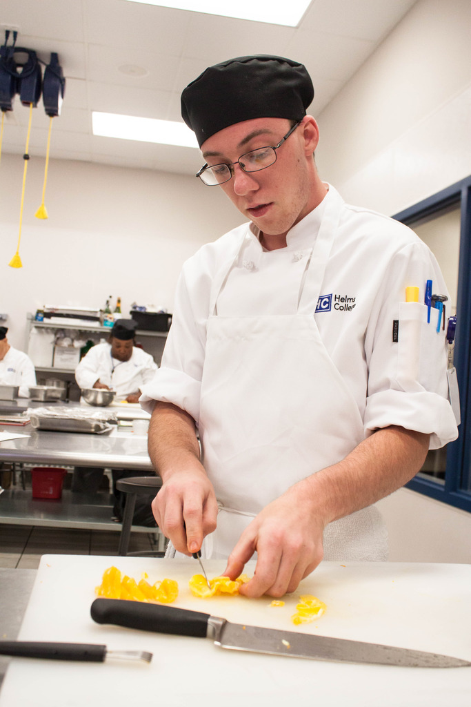 Helms College student learning knife skills Helms College student learning knife skills