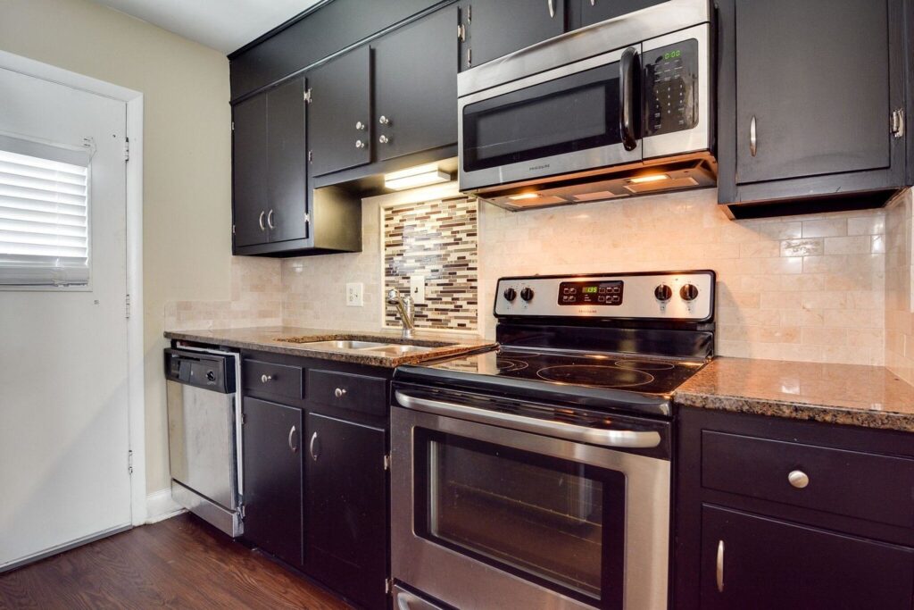 Kitchen view with stove, microwave, dishwasher and cabinetry.