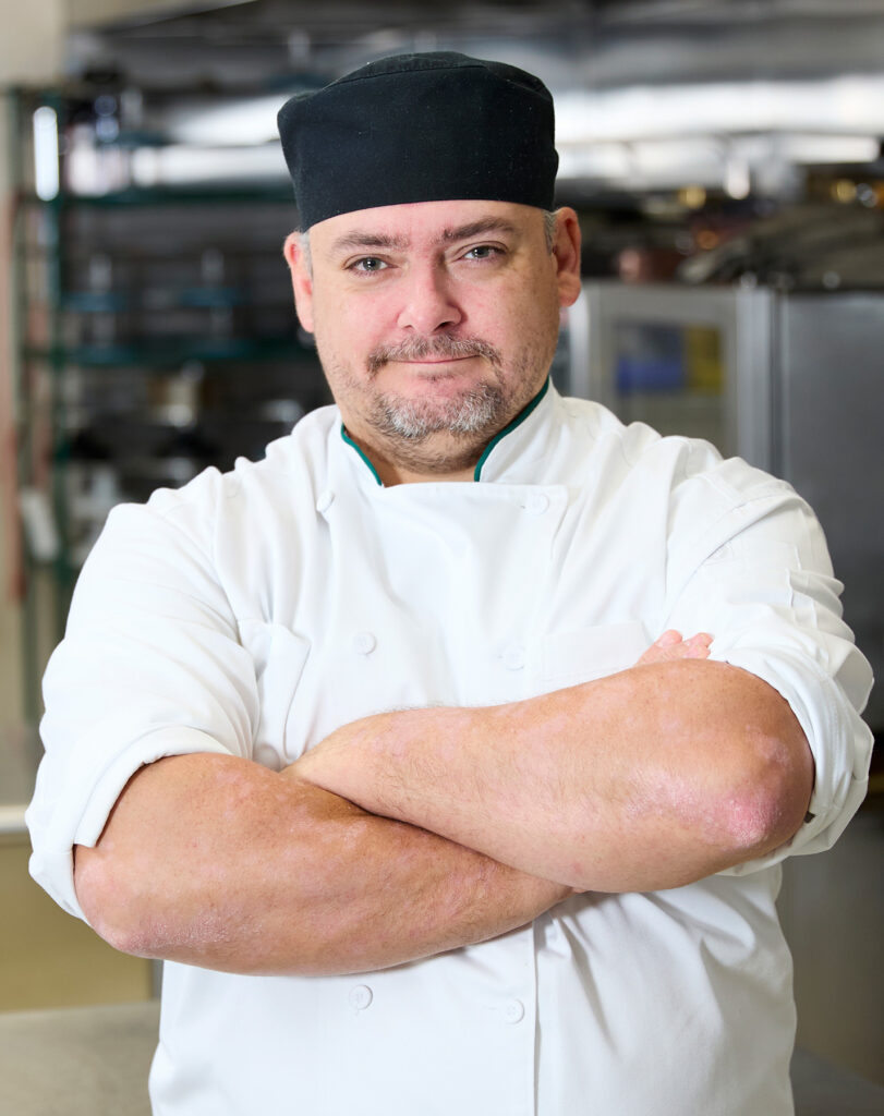 A man in a culinary chef uniform.